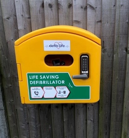 Yellow Defibrillator on a fence